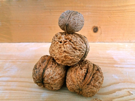 Large walnuts on a wood background, one above the other