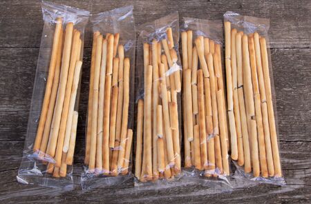 Tasty Italian bread sticks on wooden background.
