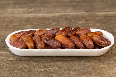 Benefits of Dates. Dates on wooden background.