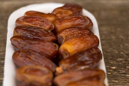 Benefits of Dates. Dried Dates on wooden background close up.の写真素材
