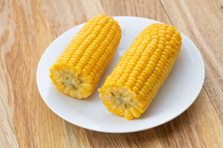 Freshly boiled corn on wooden background. Corn health benefits.の写真素材