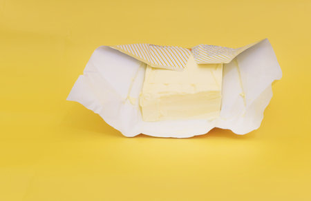 Butter on a yellow background, the benefits of butterの写真素材