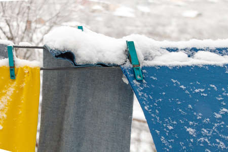 Clothes on the wire outside in the snow.の写真素材