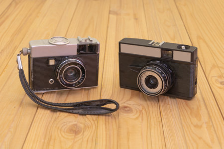Two old retro cameras on wooden background. Concept of photography history.