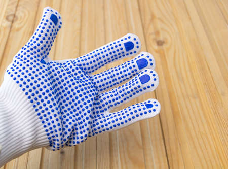 A pair of protective gloves of cotton dressed in a worker's hand.の写真素材