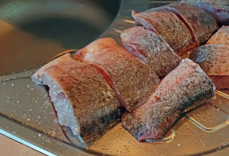 Slices of raw fish in the kitchen - in the process of cooking fish.