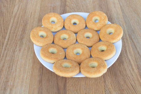 Some tasty biscuits in a plate on a wooden background.