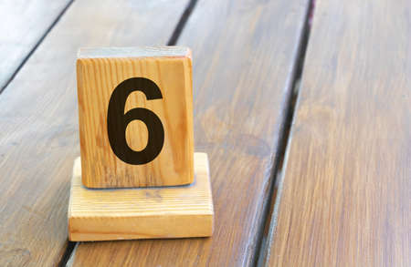 Wooden priority number 6 on a plank tab