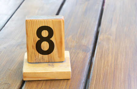 Wooden priority number 8 on a plank tab.