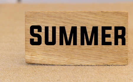 Summer text written on a piece of wood conceptの写真素材