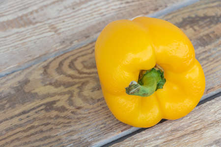 Closeup shot of yellow pepper on wooden table.の写真素材