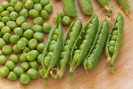 Closeup shot of fresh green peas on wooden backgroundの写真素材