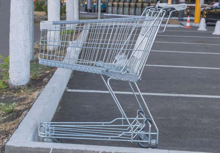 Empty shopping cart in grocery store parking lot with plastic bags insideの写真素材
