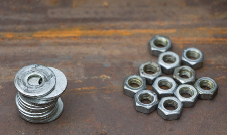 A few flat metal washers and Metal shine nuts in te background on a on a metal surface.の写真素材