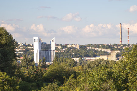 High rise building on nice summer day with industrial factory smokestack in the distance.の写真素材