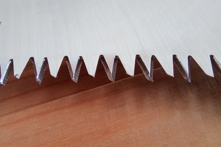 Close up of a saw blade on a wooden background. Shallow depth of field.の写真素材