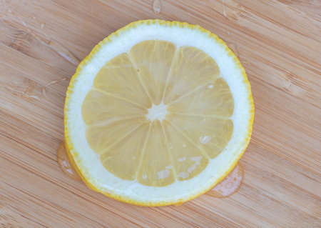 Sliced lemon with bee honey on a wooden background. Top view.の写真素材
