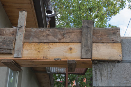 A close-up photo of a wooden beam on the wall with cement and wood beams