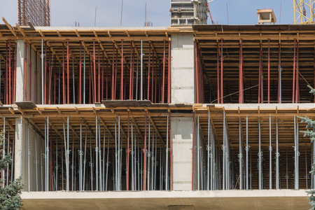 An apartment building under construction, showing the use of steel flashings and wooden beams for...