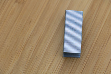 A set of staples on a wooden table, viewed from above.の写真素材
