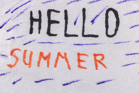 The joyful journey of hello summer, written in marker, orange and purple on white paper, close-up shot.の写真素材