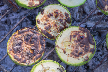 Grilled zucchini slices on the grill, close-up of charred parts of sliced vegetables.の写真素材
