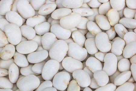 White beans, close-up of white bean texture background. White legumes for healthy food and smoothies...