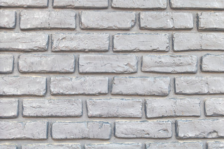 A seamless texture of light gray brick wall, perfect for adding realistic details to your projects. The brick background is made with clean lines and sharp edges that mimic the look of real bricks.の写真素材