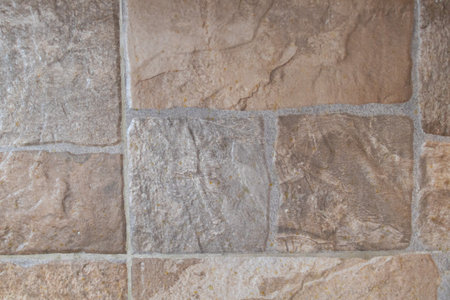 Rustic Textured Sandstone Wall with Weathered Mortar Joints in Warm Natural Tones.の写真素材
