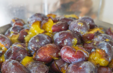 Glossy Pitted Plums in Bowl, Ready for Jam or Preserve Preparation.