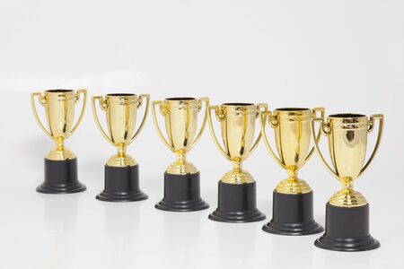 Gold trophies in a slight diagonal on white background. Horizontal.の写真素材