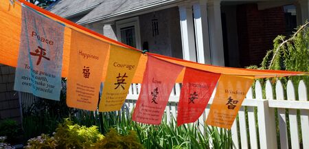 Colorful Tibetan prayer flags spanning neighborhood yard. Horizontal.