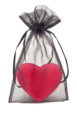 Sheer lacy black gift bag with Valentine heart inside. Isolated.の写真素材
