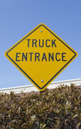 TRUCK ENTRANCE sign against blue sky. Vertical.の写真素材