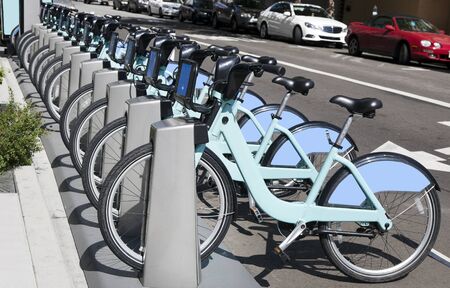 Row of green and blue urban rental bikes.