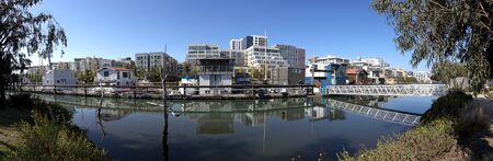 San Francisco lagoon houseboats and city skyline with blue sky.