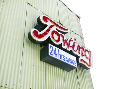 TOWING sign attached to side of industrial building.の写真素材