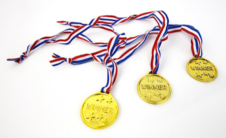 Three plastic gold WINNER medals with patriotic red, white and blue lanyards.の写真素材