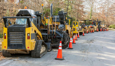 Parked asphalt pavers and rollers on neighborhood street.の写真素材
