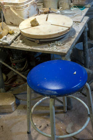 Pottery wheel at clay studio workshop with blue cushion stool.の写真素材