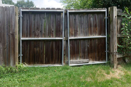 Old wooden fence gate reinforced with iron frame.の写真素材