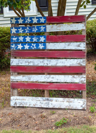 Handmade American flag made from scrap lumber displayed in neighborhood front yard.の写真素材