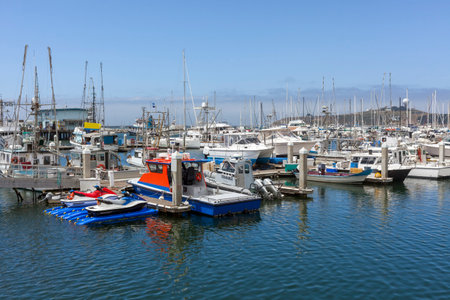 Half Moon Bay, California fishing marina with blue sky and distant fog bank.のeditorial素材