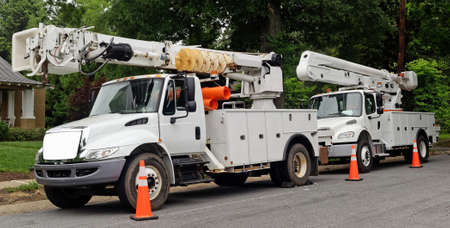 Front and side view of parked communication utility trucks in residential neighborhood. Horizontal.の写真素材