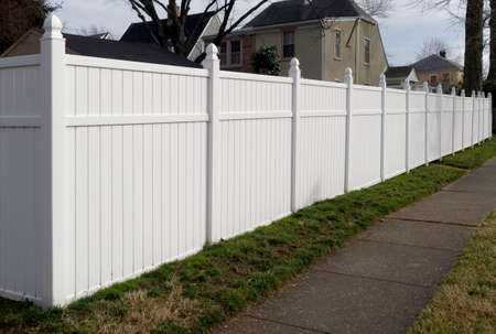 New white vinyl resin fence in residential neighborhood.の写真素材