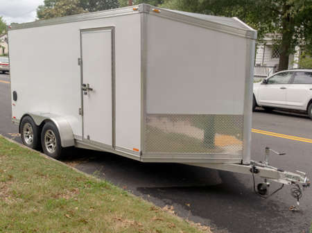 White utility trailer parked on neighborhood street.の写真素材