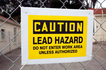 CAUTION LEAD HAZARD sign attached to chain link fence.の写真素材