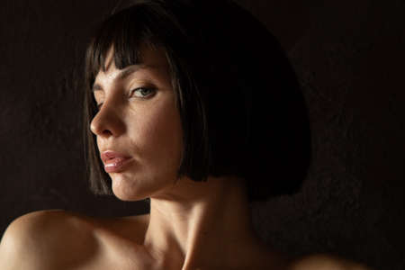 Young beautiful female model close-up studio beauty portrait. Girl with natural make-up and long brunette straight hair. Happy smiling woman with closed eyesの写真素材