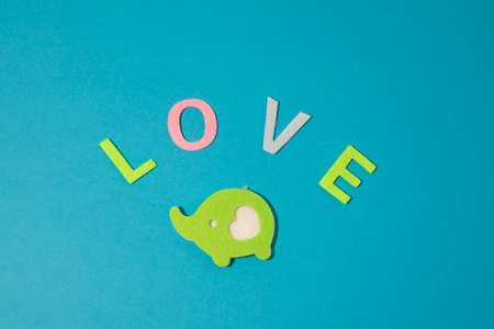 Valentines day concept with letters love and wooden heart. Decor in shape of word LOVE. white letters. Valentine concept. Color of the year 2022. Very peri tint. Selective focus.の写真素材