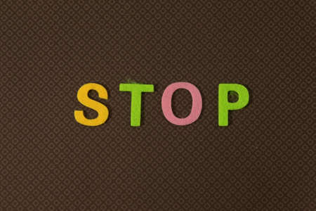 On a black background, bright multicolored stickers with the word STOP. Illustrationの写真素材